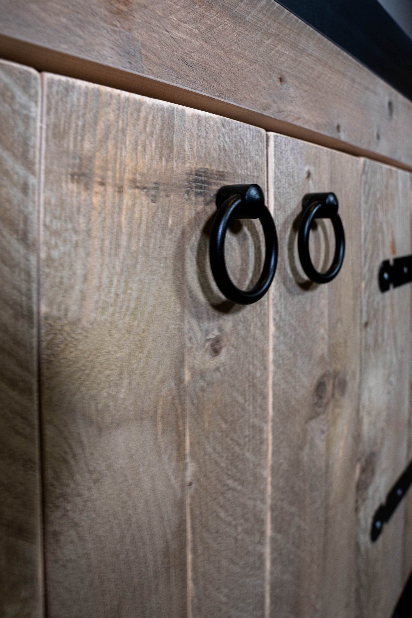 Close-up steigerhout badkamermeubel met zwarte ooggrepen